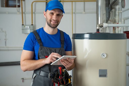 heating engineer smiling at the camera standing next to the boiler